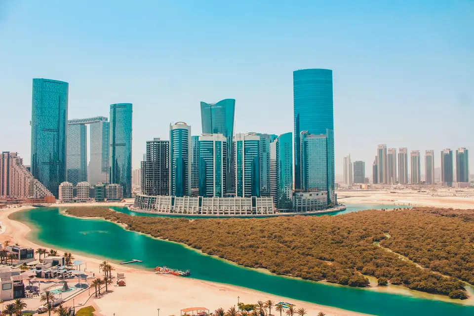 Real photograph of the residential towers, mangroves and turquoise water of Al Reem Island, Abu Dhabi.